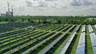 A photo that shows Orlando Utility Commission's Stanton Solar Farm outside Orlando, Florida, in September 2021. In the distance is the utility's Stanton Energy Center, powered by coal and natural gas.